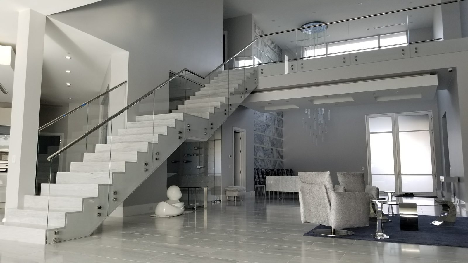 A custom floating staircase with glass railing, fabricated and installed by JD Stairs